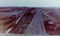 27021 & 20152 double-heading an Ayr-bound freight off the Kilmarnock line at Barassie Junction, 29 November, 1982, its only option for onward travel being the former southbound line onto the Troon loop, seen curving away to the right behind the Signalbox. The 'box had officially closed on the day before and the Troon avoiding line closed on Saturday, 27 November, the junction modified over that weekend and re-opened (deviation behind the 'box and the original 'up' line, which became the loop) that morning, all other track out of use. The Signalbox was already being demolished, one intrepid workman up on the roof stripping slates off as the train passed.<br><br>[Robert Blane 29/11/1982]