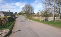 Here is the level crossing at Eassie on the Strathmore route, a crossing gate post and fencing remain, the Green house (the former gate keeper's house) and conservatory are on the track bed, this is looking west, just beyond is the A94.<br><br>[Alan Cormack 06/04/2017]