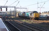 Two DRS veterans, 37069 and 37602, head a single flask from Crewe to Sellafield. The pair are seen passing through Lancaster Castle station on the Down Fast line on a bright morning, 6th April 2017.<br><br>[Mark Bartlett 06/04/2017]