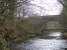 The railway viaduct just south east of Calderpark Halt once loomed high over both the North Calder Water and the still extant road bridge in the photograph. The long demolished viaduct crossed the river at an angle and continued above the left abutment of the road bridge seen here. Apart from a very short section on the west bank of the river where one of the viaduct abutments survives, the solum on both sides of the river crossing has since been landscaped and built over.<br><br>[Colin McDonald 15/02/2017]