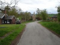 View south along Luddith Road to the former railway properties by the former North Grimston Station & Goods Yard. the former station house is ahead beyond the level crossing location, the dwelling created from the altered former platform building seen to the right, and a former workers cottage to the left.<br><br>[David Pesterfield 17/04/2017]