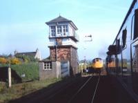 SRPS Railtour returning from Dufftown waits on the mainline for the service train to pass it on the loop below Dyce Signal Box. The reason for this unusual move may have been that the railtour train was too long for the loop so it had to wait on the mainline. The track of the Buchan Line is visible to the left of and behind the box; this line is another candidate for reopening in the 2020s.<br>
The platforms were then still disused-the station re-opened 4 years later.<br><br>[Charlie Niven 31/05/1980]