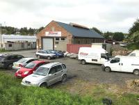 The former locomotive shed at Newton Stewart, officially closed on the last day of 1959.The building looks to be in a better condition than it was 10 years ago, having since been taken over by a vehicle servicing and repair company and equipped with a new roof [see image 15246]. View north east towards the station site in May 2017 along the trackbed of the Whithorn branch.<br><br>[Andy Furnevel 22/05/2017]