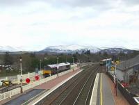 Fading light at Aviemore on the afternoon of 26 April 2017. Approaching from the south is the late running ScotRail 1334 Edinburgh - Inverness, while stabled on the Strathspey Railway siding beyond the fence is GBRf 66746 in 'Royal Scotsman' colours. <br><br>[Andy Furnevel 26/04/2017]