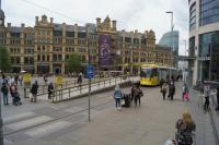 The second city crossing of Manchester by Metrolink trams takes passengers from Victoria station to St Peter's Square. Here in front of the Corn Exchange is a tram to East Didsbury at the Exchange Square stop on 19 May 2017. To the right of the photo is the Arndale shopping centre; an interesting contrast of old and new architecture.<br><br>[John McIntyre 19/05/2017]