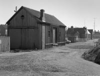 Brora goods shed with the passenger station beyond. The shed still stands, a little more decrepit. Taken on 31 March 1989 when the Far North Line was isolated by the Ness Viaduct collapse.<br><br>[Bill Roberton //1989]