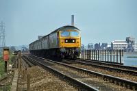 The 13.30 Ipswich to Liverpool Street crosses the River Stour at Manningtree on 13th May 1979. The industrial complex in the background is the former British Xylonite (BXL) plastics factory at Brantham which ceased production in 2007. The factory siding can be seen behind the last carriage. The site of the demolished factory was eventually redeveloped as a train maintenance and stabling depot which opened in February 2017.<br><br>[Mark Dufton 13/05/1979]