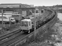 A long-welded rail train stabled on the former goods line at Dentonholme in 1986. The line had recently been closed to regular traffic when the River Caldew bridge was wrecked by a runaway train derailment [See image 59687]. Could be a new unit from local builder NEI Cowans Sheldon.<br><br>[Bill Roberton //1986]