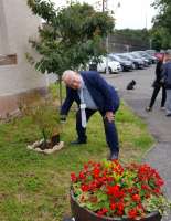 The Bridge of Allan station adopters have erected a plaque commemorating John Yellowlees' huge contribution to the station adoption programme. John is seen with the plaque in July 2017. The plaque reads:<br><br>
Planted by Friends of Bridge of Allan to mark the retiral of John Yellowlees in appreciation of the contribution he made to 'Adopt a Station'.<br><br>[David Prescott 04/07/2017]