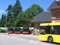 Classic German bus-rail interchange at Elzach, rural terminus of an S-Bahn local service from the university city of Freiburg in the western fringes of the Black Forest. The three red buses are operated by a DB subsidiary, the yellow bus belongs to a private operator, and in the background is a SWEG-operated Regio Shuttle train at the single-platform station.<br><br>[David Spaven 03/06/2017]