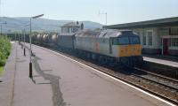 Northbound goods train at Girvan in 1989. This was one of several freight trains that day - a van, 4 tanks, 4 cartics, 2 more vans and a container.<br><br>[Ewan Crawford //1989]