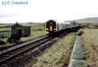 A passenger train approaches Scotscalder from the south, the old loading bank is in the foreground.<br><br>[Ewan Crawford //]