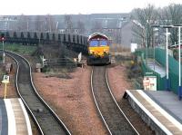 Coal empties from Longannet power station approaching Camelon, westbound, on 10 December 2004. The locomotive is crossing the bridge over the A9 alongside the overgrown island platform of the original Camelon station, with the old stairway between platform and road level still visible [see image 13253]. <br><br>[John Furnevel 10/12/2004]