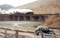 A northbound freight crossing Harthope viaduct in March 1966 behind BR Standard class 4 2-6-0 no 76098. Another example of 1950s transport stands in the foreground.<br><br>[John Robin 25/03/1966]