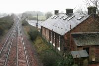 To the west beyond the car park stands the platform at Gretna Green on a rainy day in February 2006. The new station is at the start of the single line section to Annan. The former station building, now a private house, stands in the foreground.<br><br>[John Furnevel 12/02/2006]