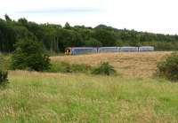 A 4-car DMU on a Tweedbank – Edinburgh service about to pass below the bridge carrying the B704 road as it approaches the Newtongrange stop on 9 July 2017. The photograph was taken from the roadside 100m west of the bridge. The wood in the background  stands on the site of the loading area and sidings that once served Lady Victoria Pit. [See image 6116] [Ref query 1096]<br><br>[John Furnevel 09/07/2017]