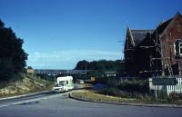 Holmsley station on the edge of the New Forest looking south east in late July 1971. The station building is on the right and the bridge in the background carried the A35 over the trackbed which by the time of the photo had been converted into a road for a few miles towards Brockenhurst.<br><br>[John McIntyre /07/1971]