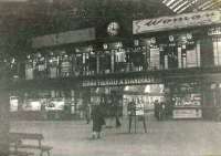 View across the passenger concourse towards the ticket barrier at St Enoch in June 1963, with trains standing at the platforms beyond. <br><br>[G H Robin collection by courtesy of the Mitchell Library, Glasgow /06/1963]