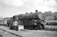 Having arrived earlier with the branch freight, Ivatt 2-6-0 43049 takes a break from shunting at Langholm in March 1965. The locomotive is standing alongside the groundframe just outside the station, which had closed to passengers in June the previous year.<br><br>[Bruce McCartney /03/1965]