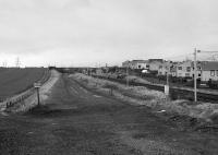 View from a diverted North Berwick-bound DMU. Looking west in 1989 along, on the left, the disused trackbed of the Lothian Lines line from Monktonhall Junction to Wanton Walls Junction, with the new Musselburgh Station on the main line beyond the bridges.  The catch points sign can be safely ignored!<br><br>[Bill Roberton //1989]