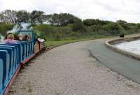 15 inch gauge 4-4-2 steam loco <I>Michael</I> takes another train around the lake loop at the Rhyl Miniature Railway, the oldest in the United Kingdom having been operational since 1911. The Chester and Holyhead main line runs along the embankment behind the wall seen here. <br><br>[Mark Bartlett 27/07/2017]