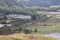 A Class 320 EMU approaches Dumbarton East along the north bank of the Clyde, as seen from the ramparts of Dumbarton Castle on 3rd August 2017.<br><br>[Mark Bartlett 03/08/2017]