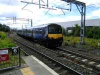 A Cumbernauld to Dumbarton Central service enters Springburn on 5 August, seconds after an opposite working using the nearer track (for Platform 2). Both trains will change ends as if this were a terminus. There are bays here, but they are very little used and indeed Platform 4 is roped off.<br><br>[David Panton 05/08/2017]