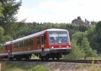 A DB Class 628 DMU approaching Dahn Süd station.  These sets, built between 1986 and 1996, consist of a power car and a trailer car, the unpowered trailer being designated class 928.  This service was en route from Bundenthal-Rumbach, the terminus of the Wieslauterbahn, to Neustadt (Weinstrasse).  After stops at Dahn and Hinterweidenthal Ort, the train will join the east-west line from Zweibrucken to Landau , then continue north to its final destination.  The rock outcrop in the background, the Lämmefelsen, is characteristic of this part of Rheinlandpfalz, with the area around Dahn being known as the Dahnerfelsenland.  [With thanks to Bill Jamieson for loco information.]<br><br>[Norman Glen 25/06/2014]