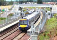 The first trains of the day in each direction on the Borders Railway cross at Shawfair station on Sunday 4 August 2017. View south from the road bridge.<br><br>[John Furnevel 04/08/2017]