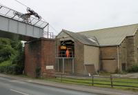 After another period of inactivity the aerial ropeway at the Claughton Manor brick works is operating again in August 2017. Further safety improvements have been made including this platform in front of the lower wheelhouse [See image 46773]. The workman seen here will release the loaded bucket for tipping and then reattach to the cable for return to the clay pit.<br><br>[Mark Bartlett 11/08/2017]