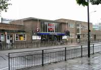 The LU White City station on the Central Line, seen here looking east across Wood Lane in July 2005. The station, which opened in 1947,  replaced the now demolished Wood Lane station, which had been the western terminus of the line (then the Central London Railway) from 1908 until 1920. Note the blue circular plaque to the left of the station entrance, commemorating a Festival of Britain design award. The station is also notable in featuring right-hand running [see image 34254].  <br><br>[John Furnevel 21/07/2005]