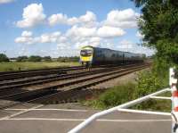 An unidentified Transpennine Express class 185 DMU, running on the Castleford line, approaches Hillam Gates level crossing near Monk Fryston during what appeared to be a day of diversions from the normal Garforth route into Leeds. A TPE 185 had earlier passed by a site I was attending, east of Castleford Station near the former junction for the Kippax line, also heading towards Leeds.    <br><br>[David Pesterfield 15/08/2017]