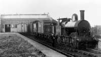 An ex-LNWR <I>Cauliflower</I> 0-6-0, LMS No. 8525, standing in Knott End station with a mixed goods train apparently ready to head back towards Garstang in a splendid but undated photograph. The glass fronted covered area for passengers between the buffers and main building can be seen but the platform is grass covered so the 1930 withdrawal of passenger services may have taken place. Later photos, but prior to the complete closure in 1950, show the covered area removed and just the brick station building visible. The loco is in a post 1928 livery but taken prior to the late 30s and early 40s renumbering of ex-LNWR locos, whereby this example would have become 28525. <br><br>[Knott End Collection //]