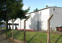 Following closure of Loanhead station in 1965 the old goods yard was taken over as a works compound by Midlothian Council. As part of recent changes within the yard the original wooden goods shed [see image 13631] has been replaced by a larger, more modern structure, seen here on 24 August 2017. The pleasant surprise is that the short length of surviving track terminating at a buffer stop within the compound has been left in situ.<br><br>[John Furnevel 24/08/2017]