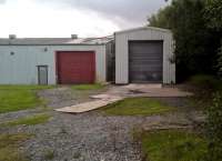 HPE had a similar business model to Alan Keef Limited, retaining and using their skills in steam locomotion until their sad demise in 1996. The building with the red door was their main factory; that with the grey door was a locomotive shed. The sleepers at lower right were at the start of a dead straight quarter mile long test track, which ran alongside one of the industrial estate roads. There was no connection to the national network, but the line ran slightly North of the former LNWR Heads of the Valleys line.<br><br>[Ken Strachan 19/08/2017]