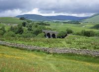 Appersett Viaduct carried the Midland Railway's Garsdale to Hawes branch (closed 1959) over Widdale, a side valley of Wensleydale, just over a mile to the west of Hawes. The westernmost arch is completely obscured by trees so that in this view from a footpath to the south-east the full length of the structure is not obvious.<br>
<br>
<br><br>[Bill Jamieson 15/06/2017]