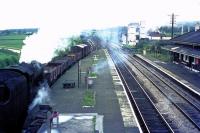 An unidentified LMS 8F 2-8-0 shunting alongside the old G&KER platform at Garstang & Catterall station. This view looks north from the station footbridge with the Lancaster Canal visible to the left of the steam plume. The main goods yard was behind the camera but the Creamery alongside the Up line also used rail for many years. The line immediately to the left of the main running lines beyond the island platform was the old link to the Knott End branch, which also later formed a long Down goods loop for the main line. [See image 19991] <br><br>[Knott End Collection //]