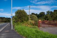 The site of the original terminus of the Glasgow, Barrhead and Neilston Direct Railway was on the left. On the right is the original route of the road, which has been replaced by the new alignment through the former station site on the left. The view looks east. The line was extended south to [[Kilmarnock]] and a new Neilston station opened on the extension.<br><br>[Ewan Crawford 14/09/2017]