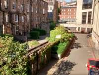 Edinburgh Princes Street Station, which closed in 1965, was wedged between Rutland<br>
Street/Square and Lothian Road. The site is now a financial district. The<br>
bridge I am standing on (looking north east) didn't exist at the time.<br>
Under me there were sidings 5 wide between the back gardens of Rutland<br>
Square (left) and the outside wall of the station was more or less where<br>
the building is on the extreme right. If the closure did nothing else it<br>
did provide a useful 'urban fastway', as it was called, on the trackbed of<br>
the approaches. Miraculously this is rarely congested even today. <br>
[See image 35223].<br><br>[David Panton 17/09/2017]