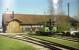 A steam outline diesel tram locomotive stands outside the shed and workshops of the Chiemsee-Bahn at Prien-Stock in Bavaria. The photo was taken in April 1989 and at the time, the station of this short narrow gauge line was to the left. It is understood that the shed in this photo was demolished in 2011 and replaced with a new building and station. The station is next to a pier for ferries sailing on Chiemsee, including to Herreninsel and island where the palace of Herrenchiemsee is situated. The palace was built for King Ludwig II of Bavaria and is based upon the palace of Versailles.<br><br>[John McIntyre /04/1989]