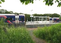 Approaching the pathway running along the south side of Tweedbank station in June 2017 via the shortcut from Tweedbank Drive. Just pulling into platform 1 is ScotRail 158734 with the 1024 ex-Edinburgh Waverley. The 158 on the right at platform 2 remains stabled there for much of the day.<br><br>[John Furnevel 16/06/2017]