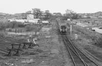 156496 leaves the loop at Elgin heading for Aberdeen in 1991. The buffer stops of Elgin goods yard can be seen on the left and the site of a rail-connected timber yard on the right.<br>
<br>
<br><br>[Bill Roberton //1991]