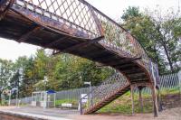 The rusty footbridge at Addiewell looking from the north to the south platform. This station is approached on either side by electrification masts.<br><br>[Ewan Crawford 08/10/2017]