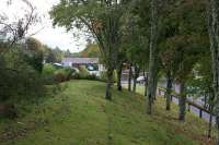 A view east along the former railway embankment in Banchory, with the car through the trees on Dee Street. This was the site of Dee Street Halt, a short wooden structure opened in February 1961 and closed along with the line just five years later. [Ref query 12 October 2017]<br><br>[John McIntyre 18/10/2012]