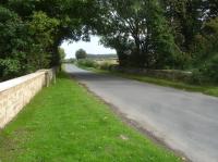 Looking east across overbridge HMY 8 on Station Road immediately south of the former Nunnington Station located between Gilling East and Helmsley on the route to Pickering. The new wall is the boundary wall to the large lawn running up from the former station, with the drive entrance to rear of view. <br><br>[David Pesterfield 24/09/2017]