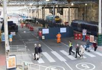 Scene at Waverley looking east from the cross-station walkway on 5 October 2017.  The compound enclosing the works for the extended platforms 5 and 6 is now in place (complete with <I>'minder'</I>). To the right is the rear end of the 1137 service to Milngavie standing alongside platform 11, while in the background, at the buffer stops beyond the east end of platform 10, is Serco Sleeper locomotive 92010.<br><br>[John Furnevel 05/10/2017]