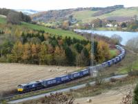 Diverted over the Perth - Ladybank route, DRS 66423 climbs past Lindores Loch with Inverness - Mossend containers on 6th November 2016.<br>
<br>
<br><br>[Graeme Blair 06/11/2016]