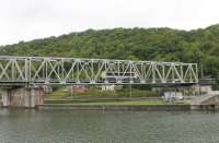 SNCB electric loco No. 1313 crosses the Meuse bridge at Anseremme heading southwards light engine on 8th September 2017. This is a picturesque spot with a lock, weir and also the confluence of the Meuse and Lesse rivers. The disused tracks of the line to Givey lie in front of the houses on the far bank. <br><br>[Mark Bartlett 08/10/2017]