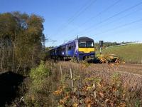 Just after crossing the new M8 viaduct, 320411 heads towards the site of Tannochside Junction. The trees on the left mark the solum of the former Tannochside Branch. The uncommisioned signal with a bag over its head seen to the right of the cab is part of the Motherwell North Signalling Renewals work. [See image 49737] for the same view in diesel days.<br><br>[Colin McDonald 27/10/2017]