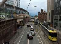 A recently installed footbridge offers an excellent viewpoint from which to watch the distant wall under Piccadilly station ingesting and ejecting trams. Main line trains can also be seen crossing the grey bridge in the distance.<br><br>[Ken Strachan 29/07/2017]